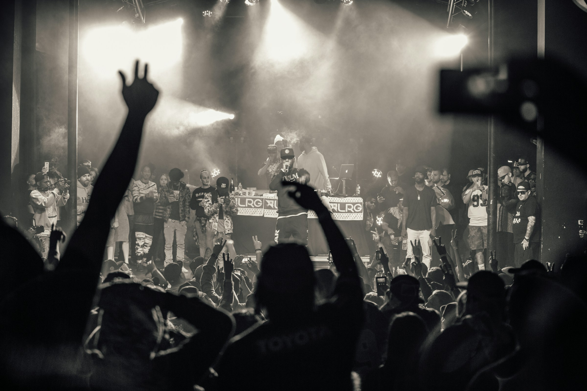 Crowd with raised hands in front of a concert stage